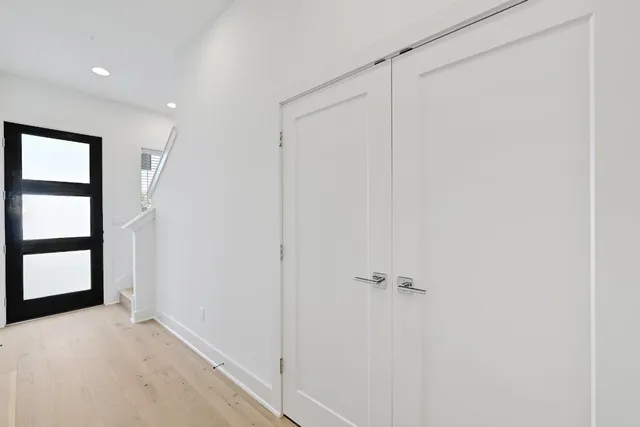a view of large kitchen with stainless steel appliances wooden floor and large window