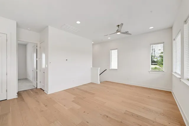 a kitchen with stainless steel appliances a stove top oven a refrigerator a center island with wooden floor and cabinets