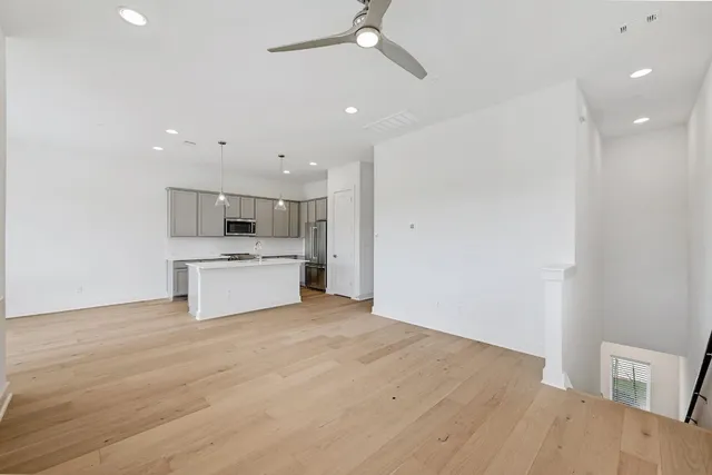 a kitchen with stainless steel appliances granite countertop a sink stove and white cabinets with wooden floor