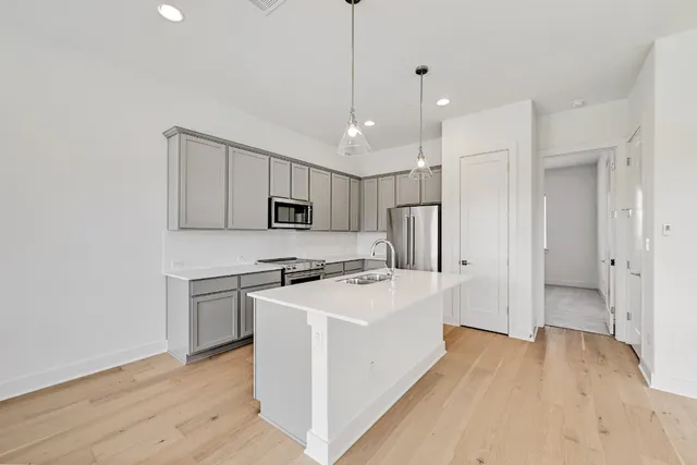 a kitchen with kitchen island a sink stainless steel appliances and cabinets