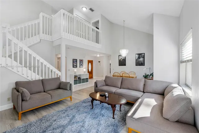 a living room with furniture a rug and a chandelier
