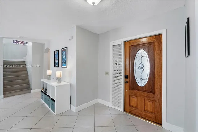a large white kitchen with granite countertop a large window and a counter top space