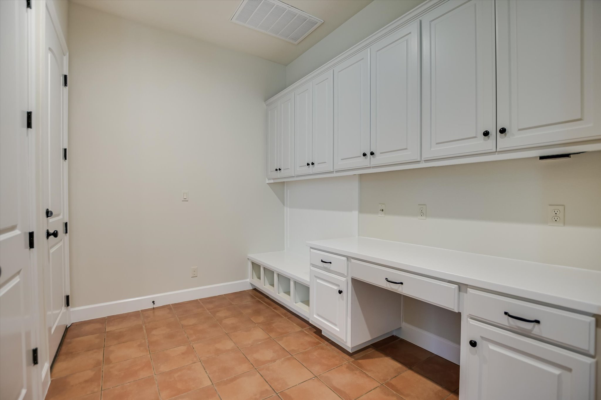 11 Inwood Circle Austin, TX 78746 - Photo 17 of 38 Functional mudroom with tile flooring and ample built-in storage and desk space.
