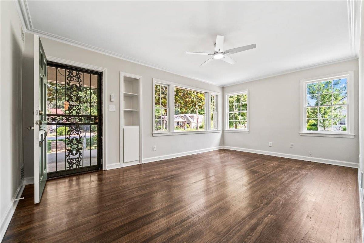 170 South Greer Street Memphis, TN 38111 - Photo 19 of 35 Spacious room featuring wood-finish flooring, a contemporary ceiling fan with integrated lighting, multiple pane windows, and a built-in shelving unit