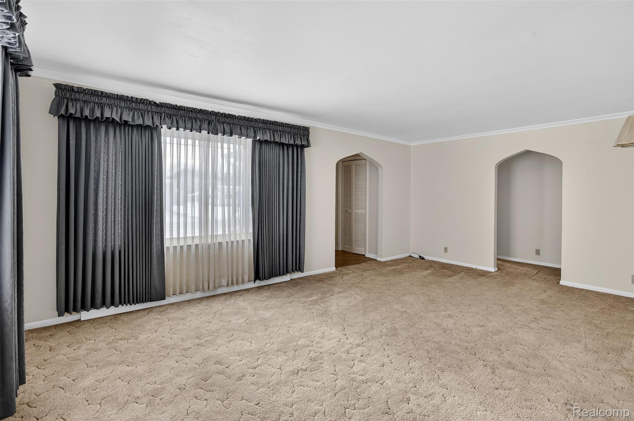 3241 Curtis Road Birch Run, MI 48415 - Photo 14 of 47 Spare room featuring light colored carpet, crown molding, and arched walkways