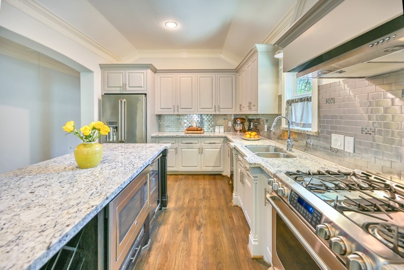 1122 East 23rd Street Houston, TX 77009 - Photo 4 of 23 Chef-inspired kitchen with expansive island, stainless steel appliances, and abundant custom cabinetry.
