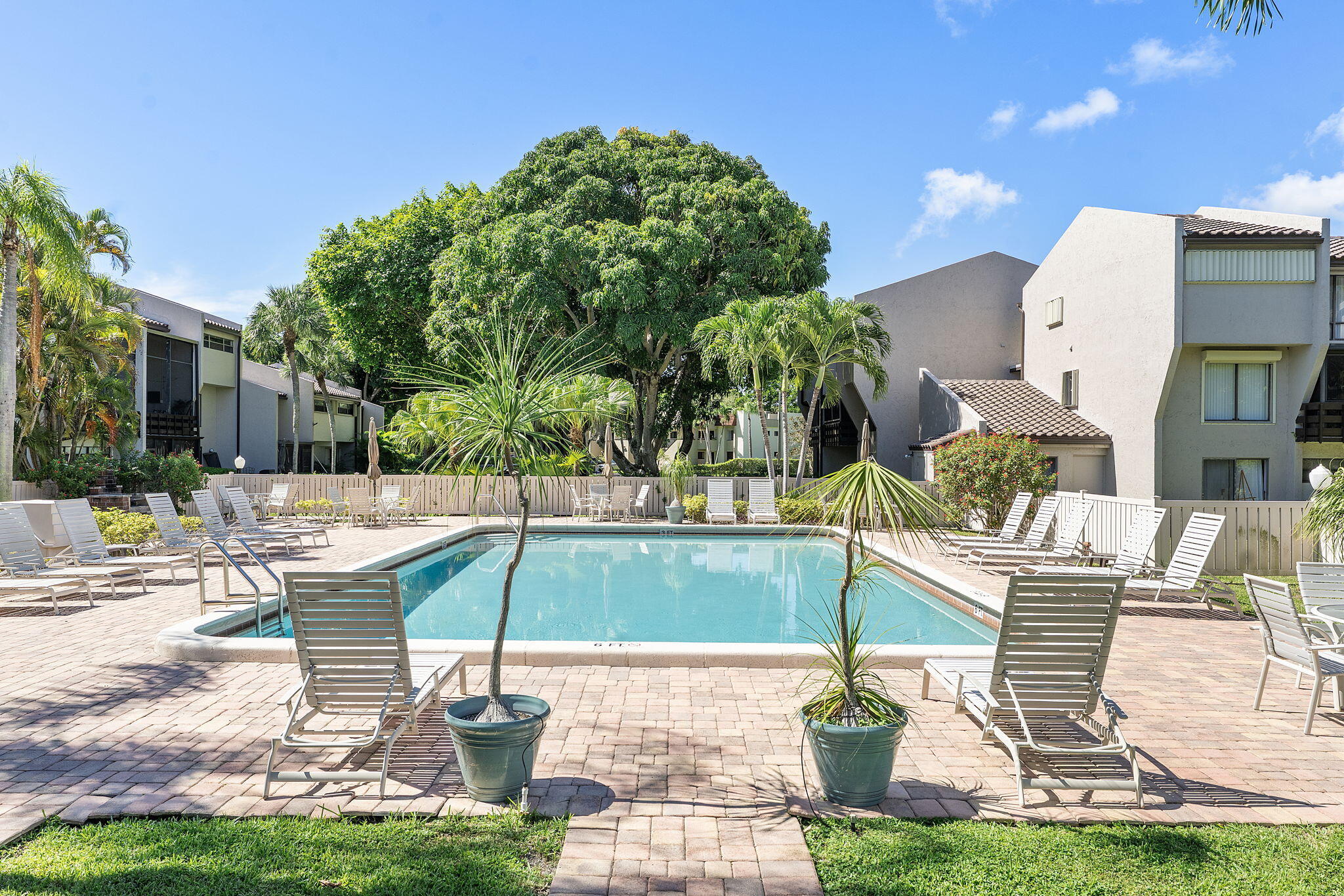 159 Northwest 70th Street, Unit 603 Boca Raton, FL 33487 - Photo 27 of 35 a patio with a table and chairs potted plants
