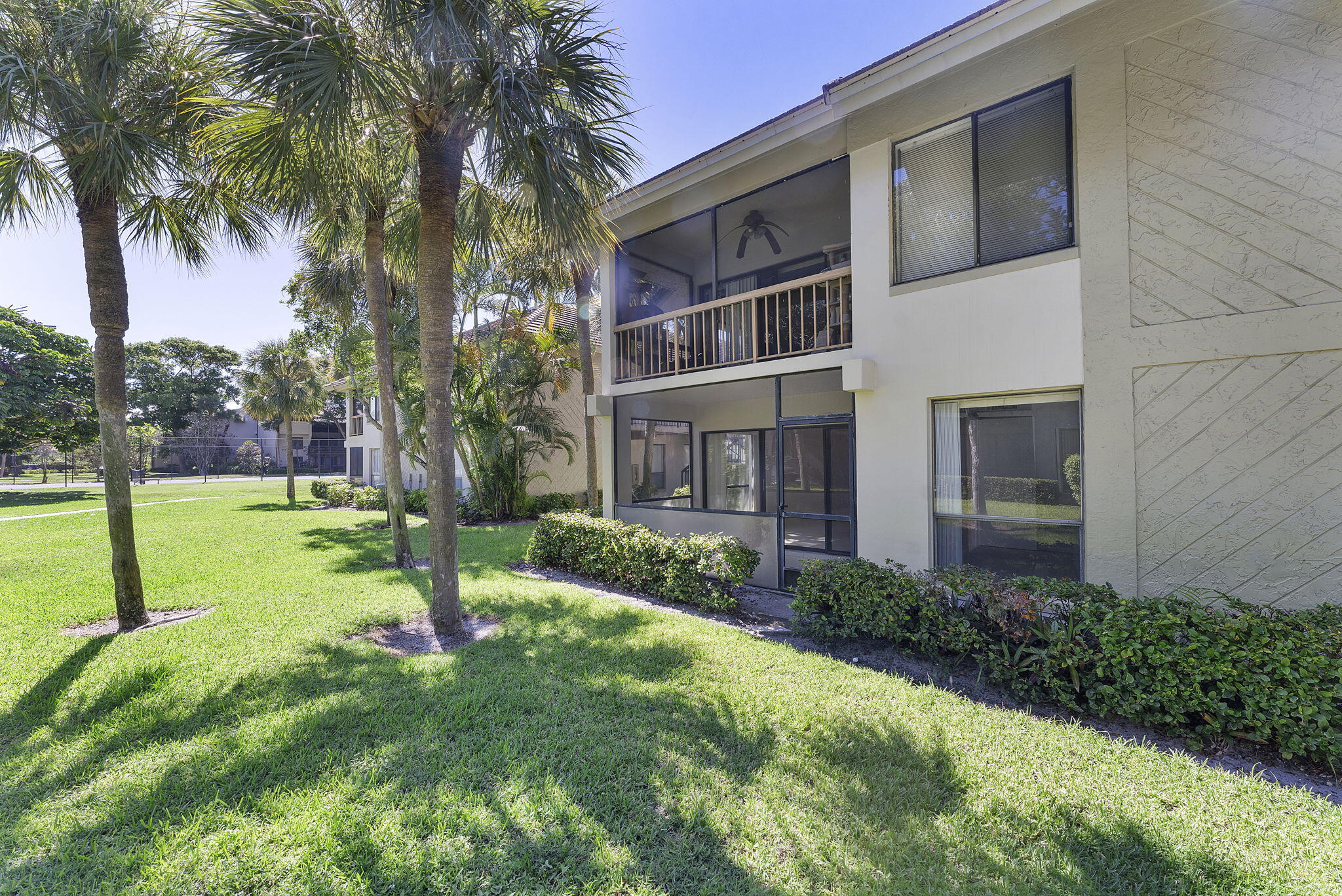159 Northwest 70th Street, Unit 603 Boca Raton, FL 33487 - Photo 32 of 35 a view of a house with a yard and palm trees