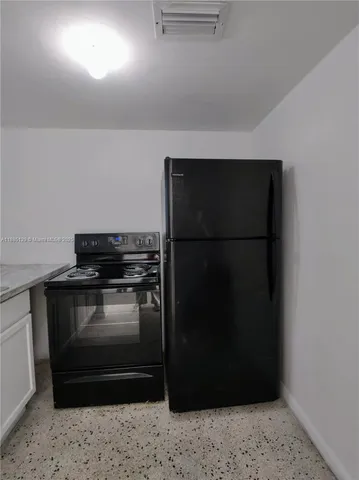 a kitchen with a refrigerator and a stove