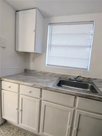 a kitchen with white cabinets and a sink
