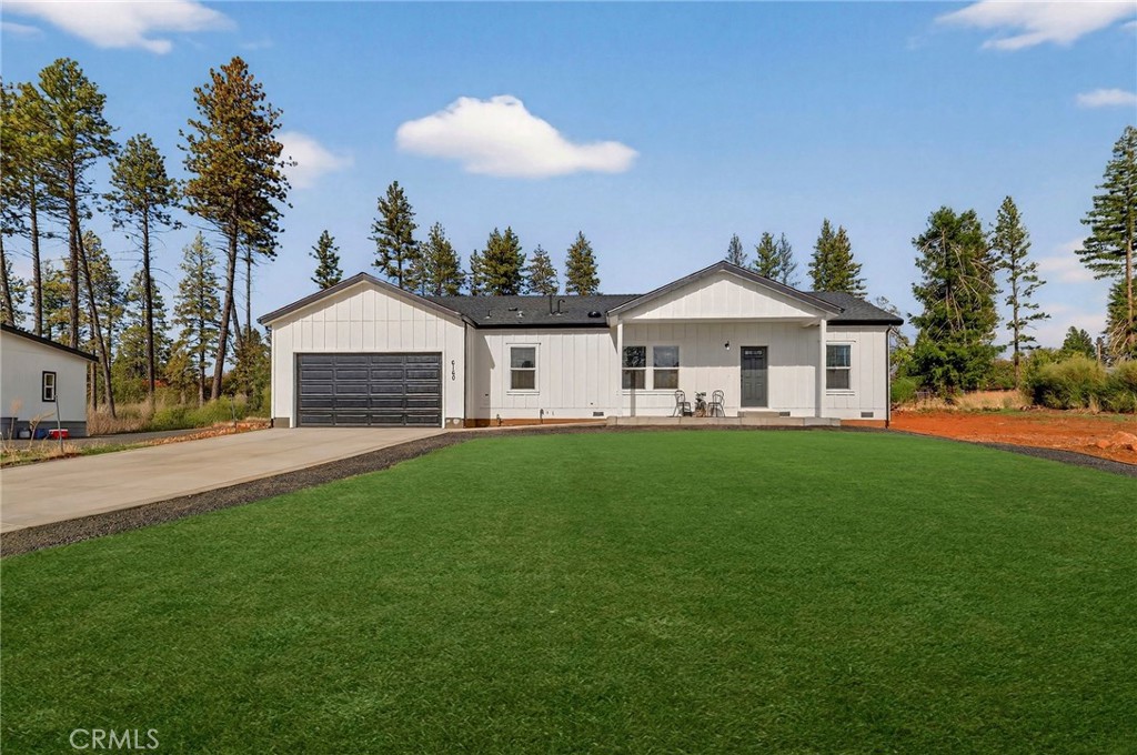 a front view of a house with a garden and yard