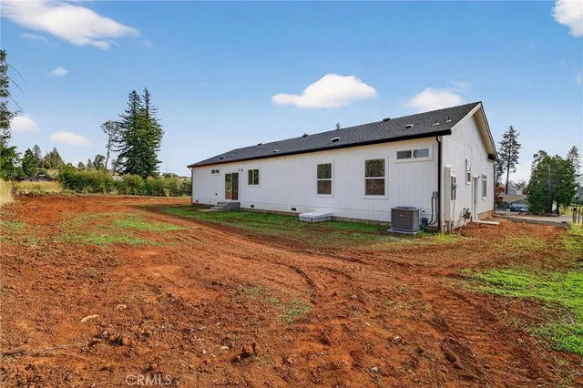 a view of a house with backyard and trees