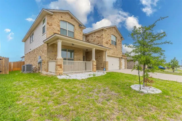 a view of a big house with a big yard and large tree