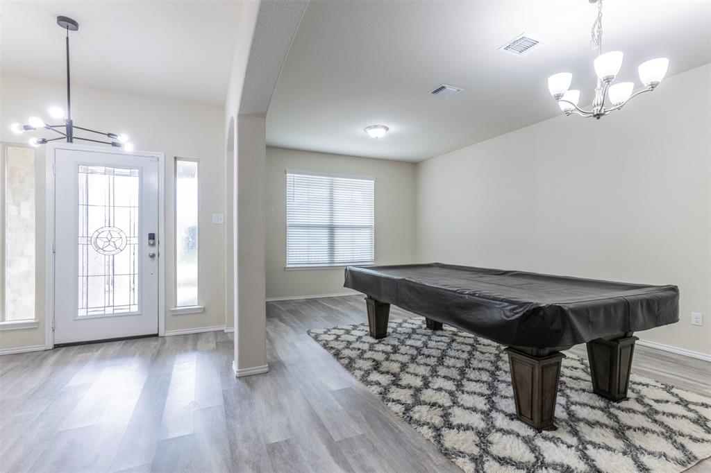 2904 Beutel Road Lorena, TX 76655 - Photo 12 of 40 a dining room with wooden floor a chandelier a wooden table and chairs