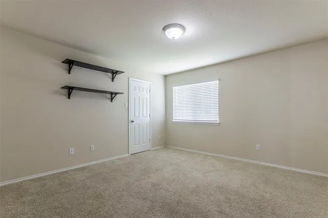 an empty room with windows and a ceiling fan