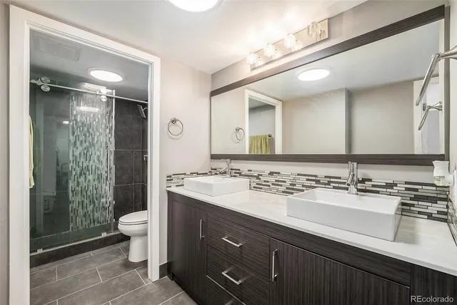 a bathroom with a double vanity sink toilet and shower