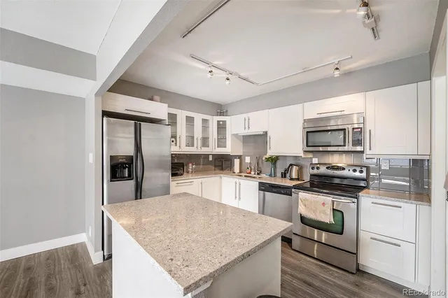 a kitchen with stainless steel appliances granite countertop a sink stove microwave and refrigerator