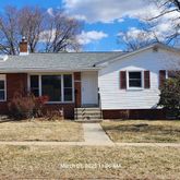 a front view of a house with a yard covered in snow