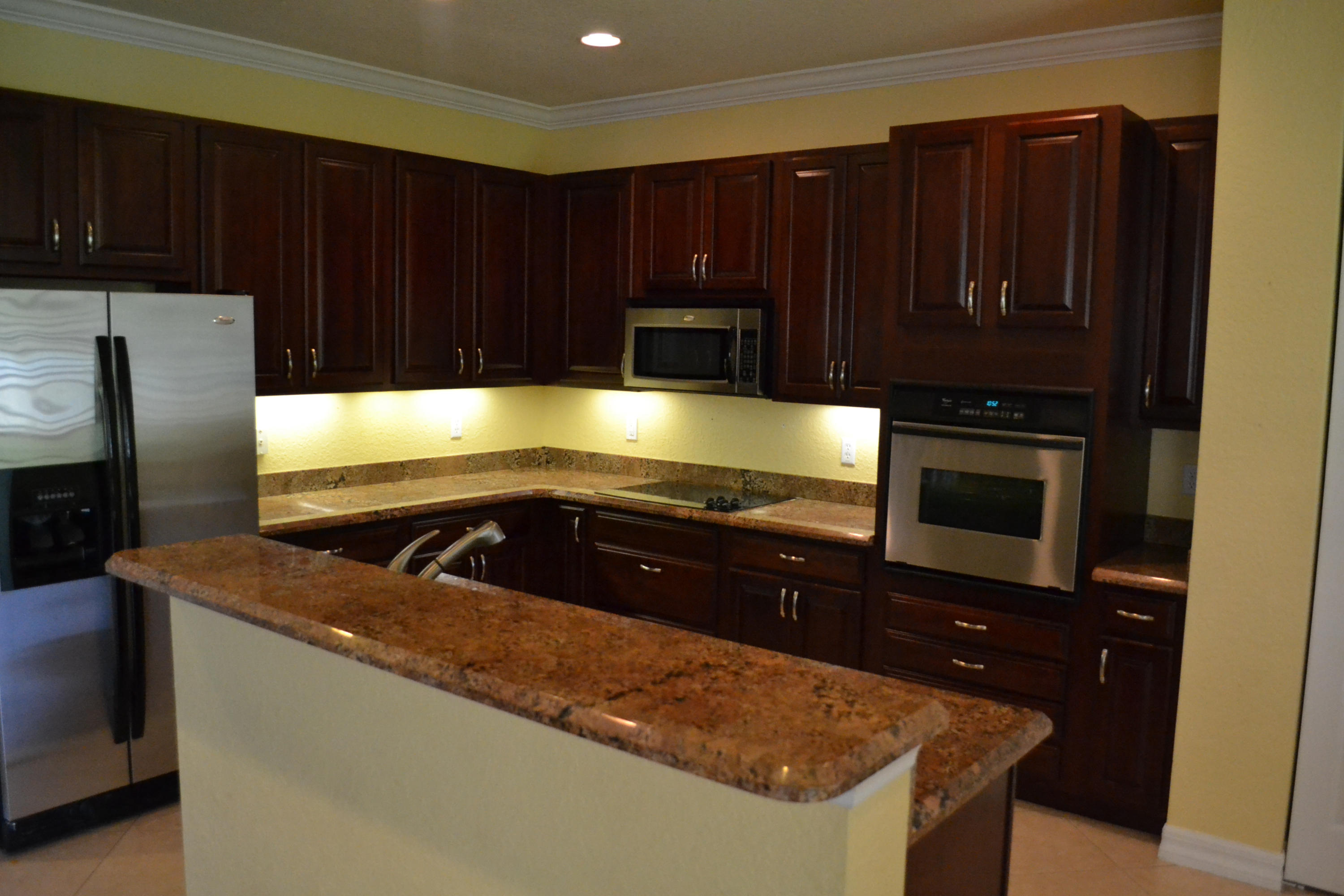 124 Dunmore Drive Jupiter, FL 33458 - Photo 8 of 10 a kitchen with wooden cabinets and a sink