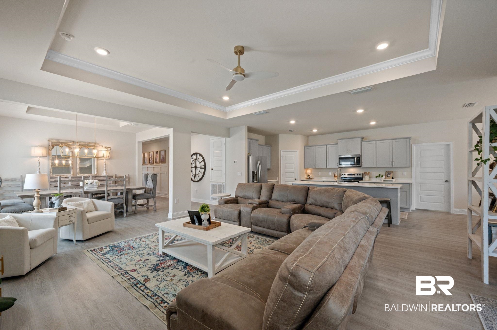 681 Calibre Street Fairhope, AL 36532 - Photo 26 of 56 Living room featuring ceiling fan with notable chandelier, light hardwood / wood-style floors, and a raised ceiling