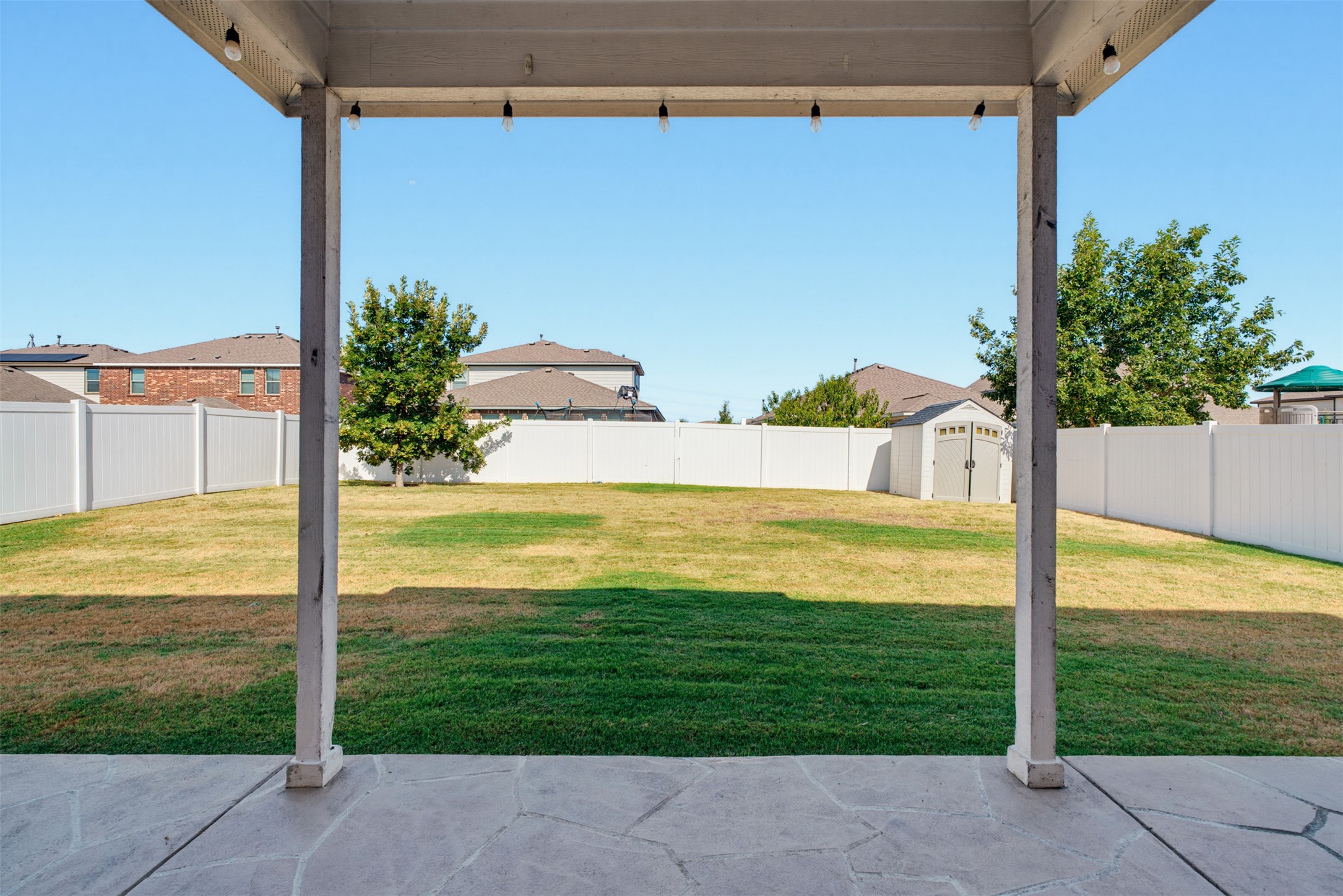 11008 Players Path Austin, TX 78747 - Photo 22 of 26 A spacious, fully fenced lawn stretches beyond the shaded stone patio.