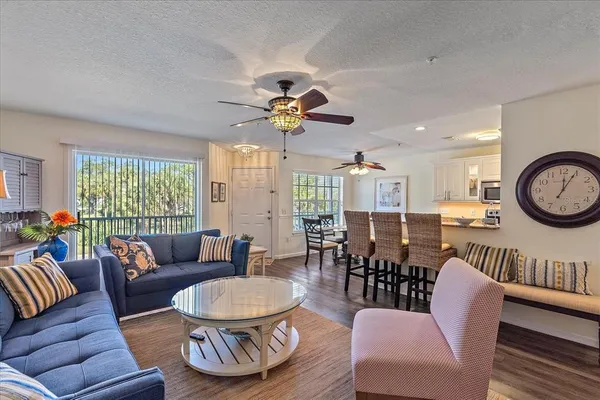 a living room with furniture a chandelier and a large window