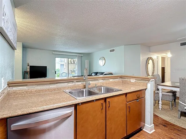 a kitchen with stainless steel appliances granite countertop a stove a microwave and wooden cabinets
