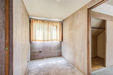 a view of an empty room with window and bathroom