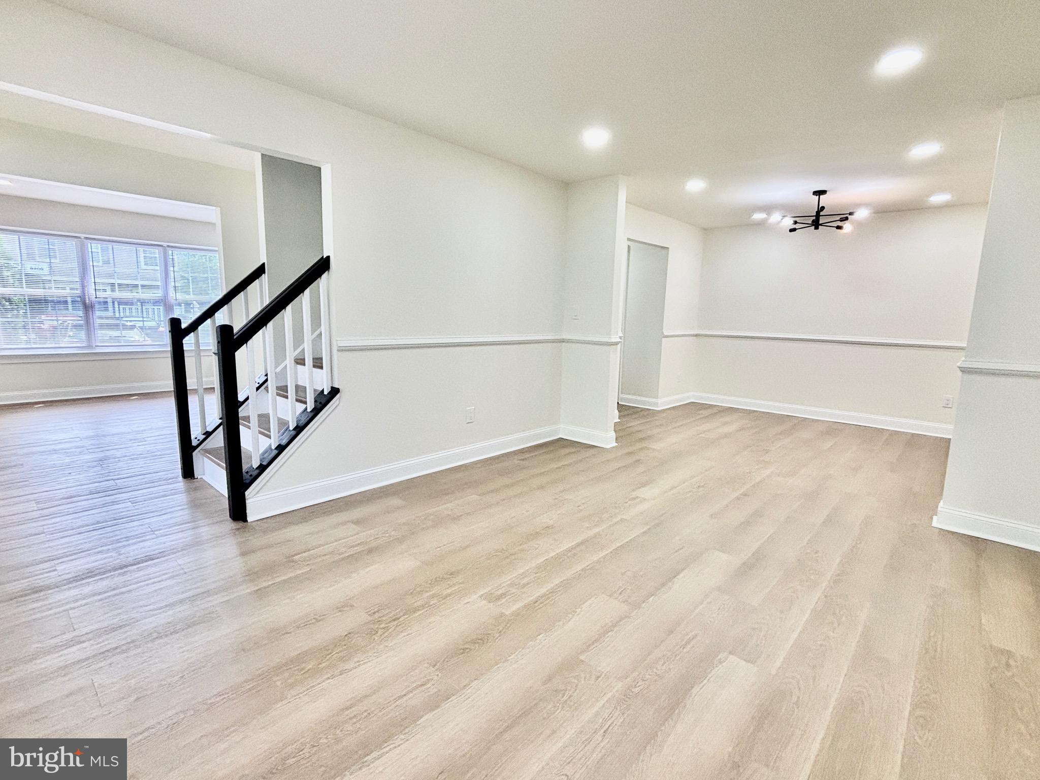 a view of an empty room with stairs and a ceiling fan