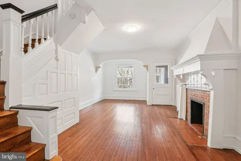 a view of empty room with wooden floor and fireplace