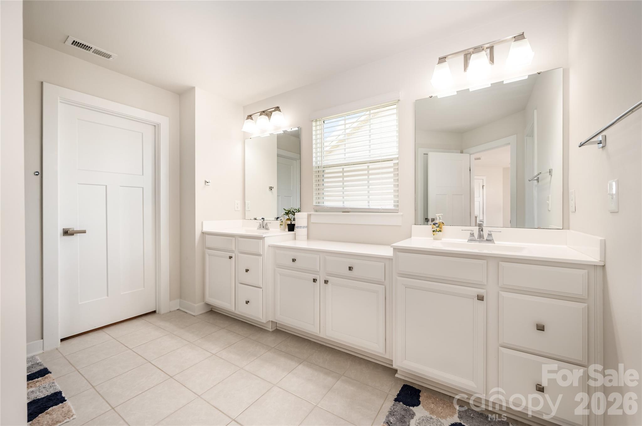 7222 Waterwheel Street Southwest Concord, NC 28025 - Photo 21 of 48 a spacious bathroom with double sink large mirror and a window