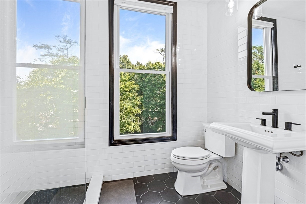 5 Babson Street, Unit 2 Gloucester, MA 01930 - Photo 11 of 23 a bathroom with a toilet a sink a mirror and a window