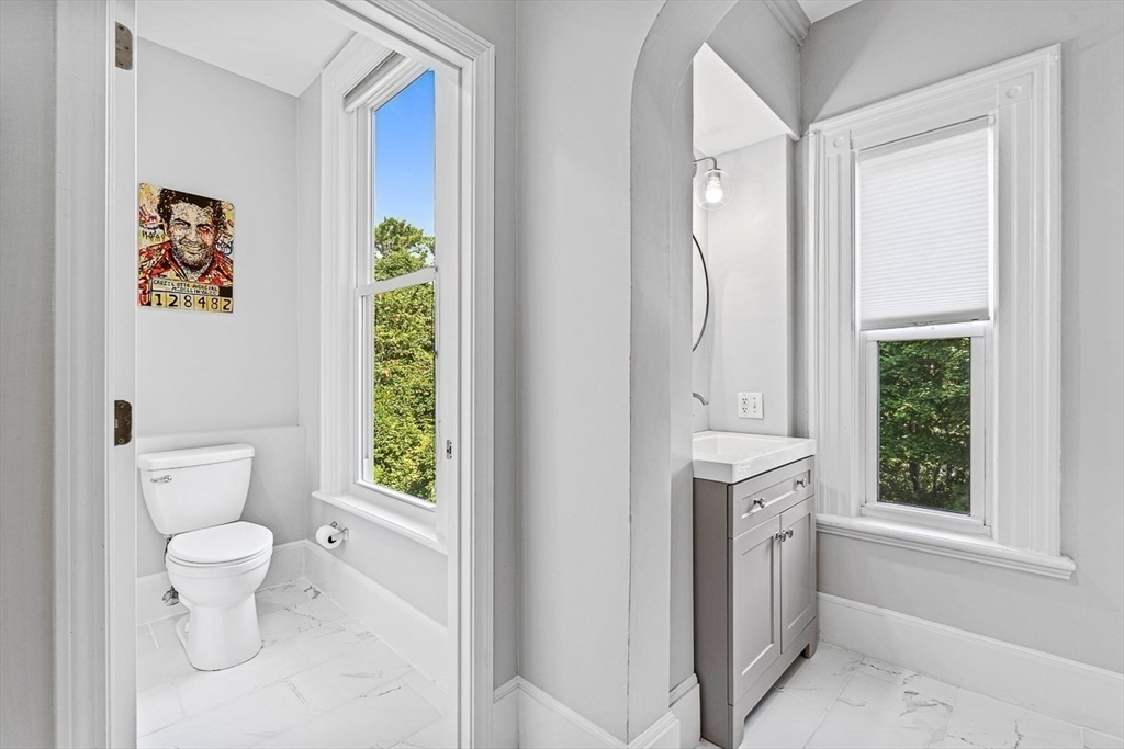 5 Babson Street, Unit 2 Gloucester, MA 01930 - Photo 14 of 23 a bathroom with a granite countertop sink a toilet and a window