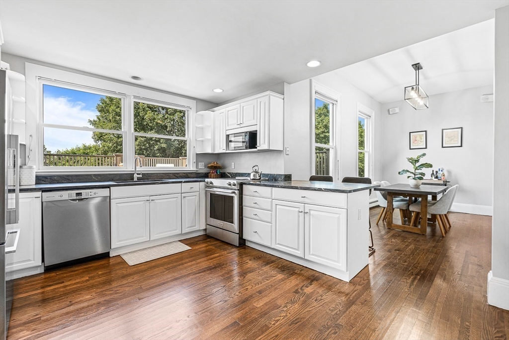 5 Babson Street, Unit 2 Gloucester, MA 01930 - Photo 7 of 23 a kitchen with granite countertop white cabinets and white appliances