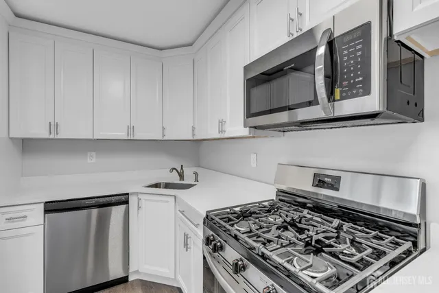 a kitchen with stainless steel appliances a stove a microwave sink and cabinets