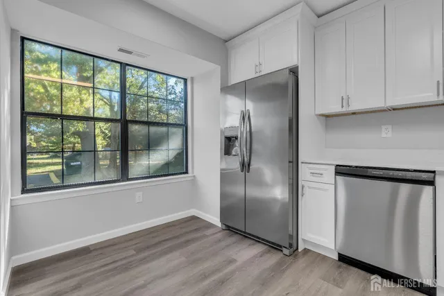 a kitchen with stainless steel appliances granite countertop a refrigerator and a window