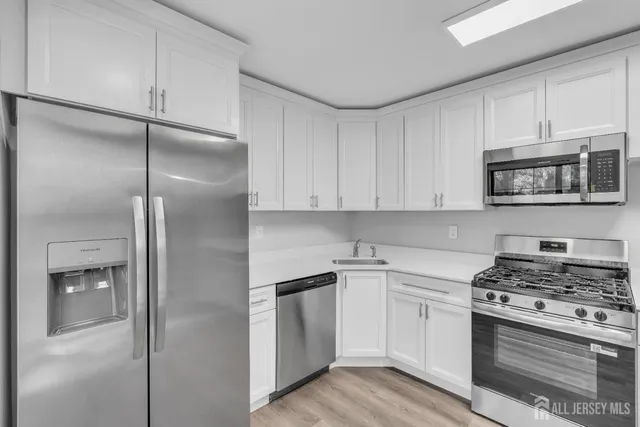 a kitchen with cabinets stainless steel appliances and a counter space