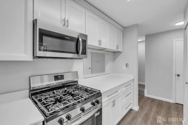 a kitchen with white cabinets and appliances