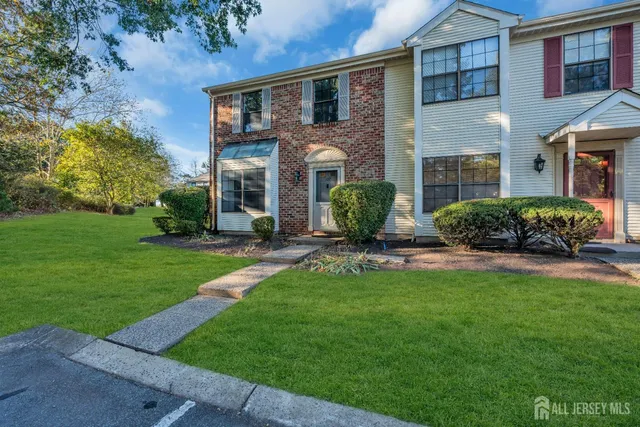 front view of a brick house with a yard