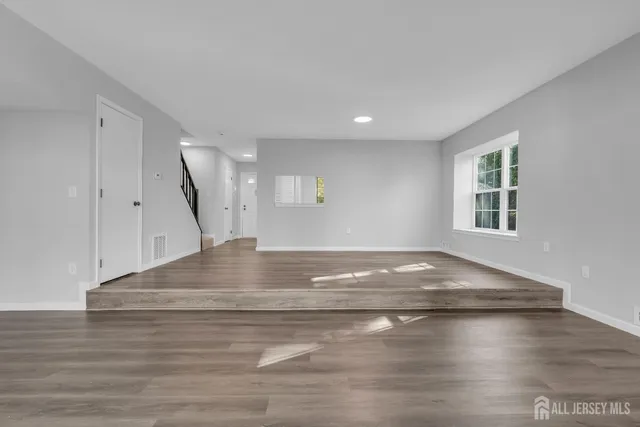 a view of empty room with wooden floor
