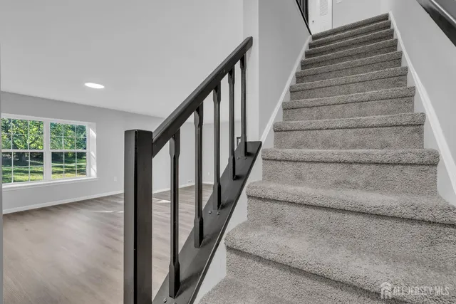 a view of staircase with wooden floor and white walls