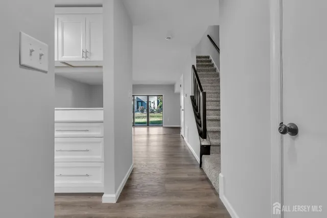 a view of a hallway with wooden floor and staircase
