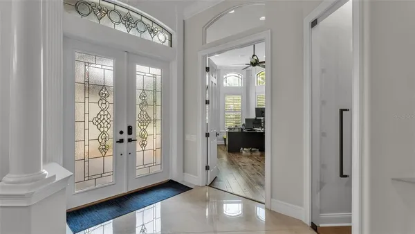 a living room with furniture a large window and a mirror