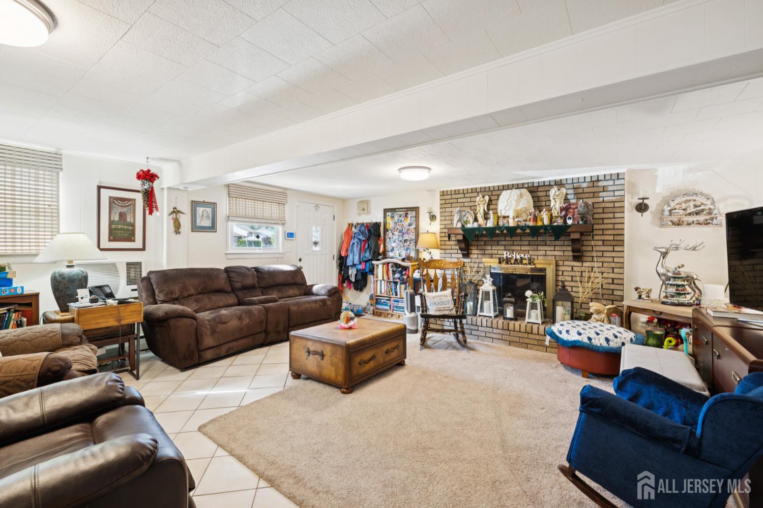 266 Amherst Avenue Colonia, NJ 07067 - Photo 11 of 22 a living room with furniture a fireplace and a flat screen tv