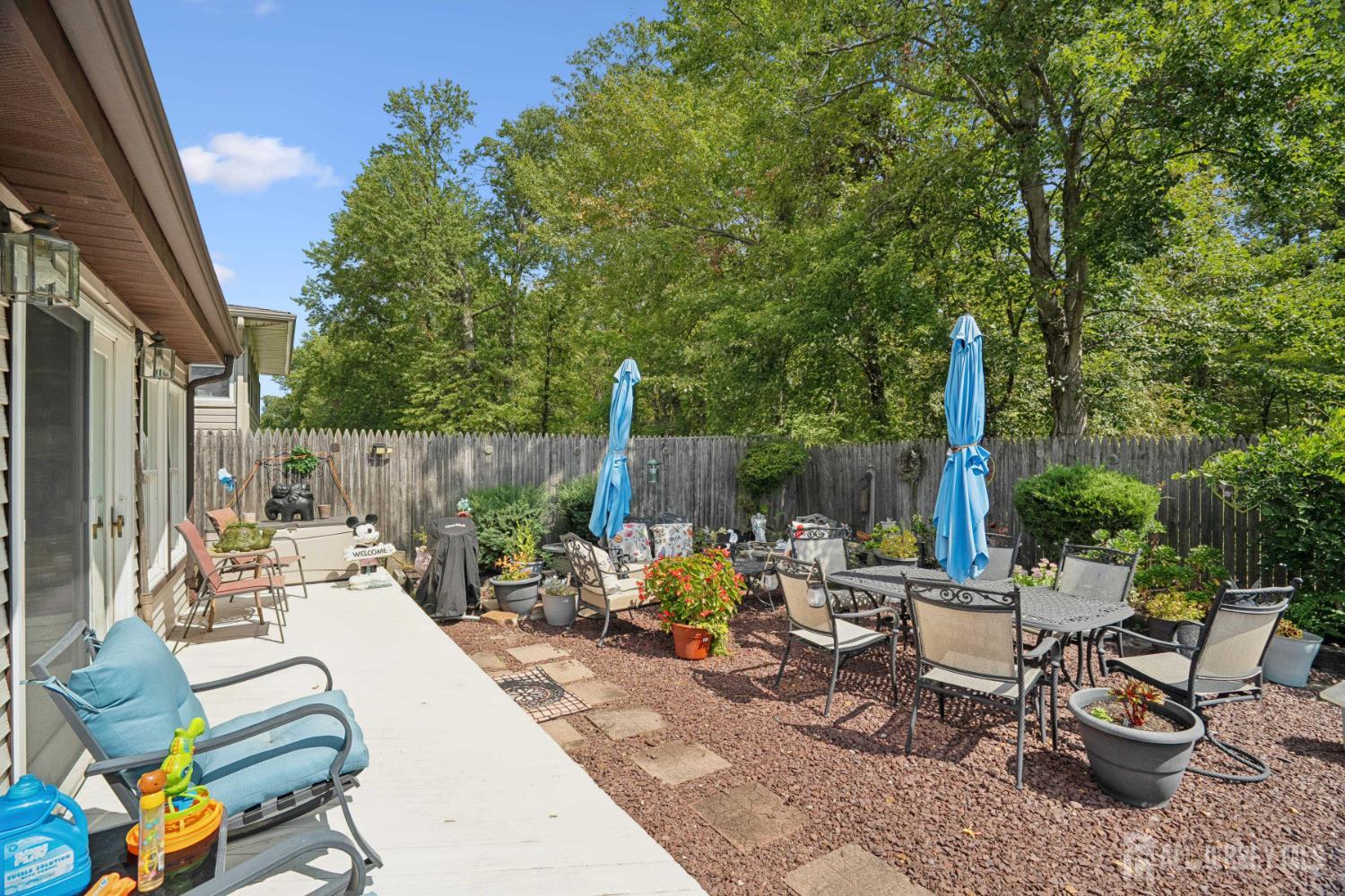 266 Amherst Avenue Colonia, NJ 07067 - Photo 22 of 22 a view of a patio with table and chairs potted plants and a palm tree