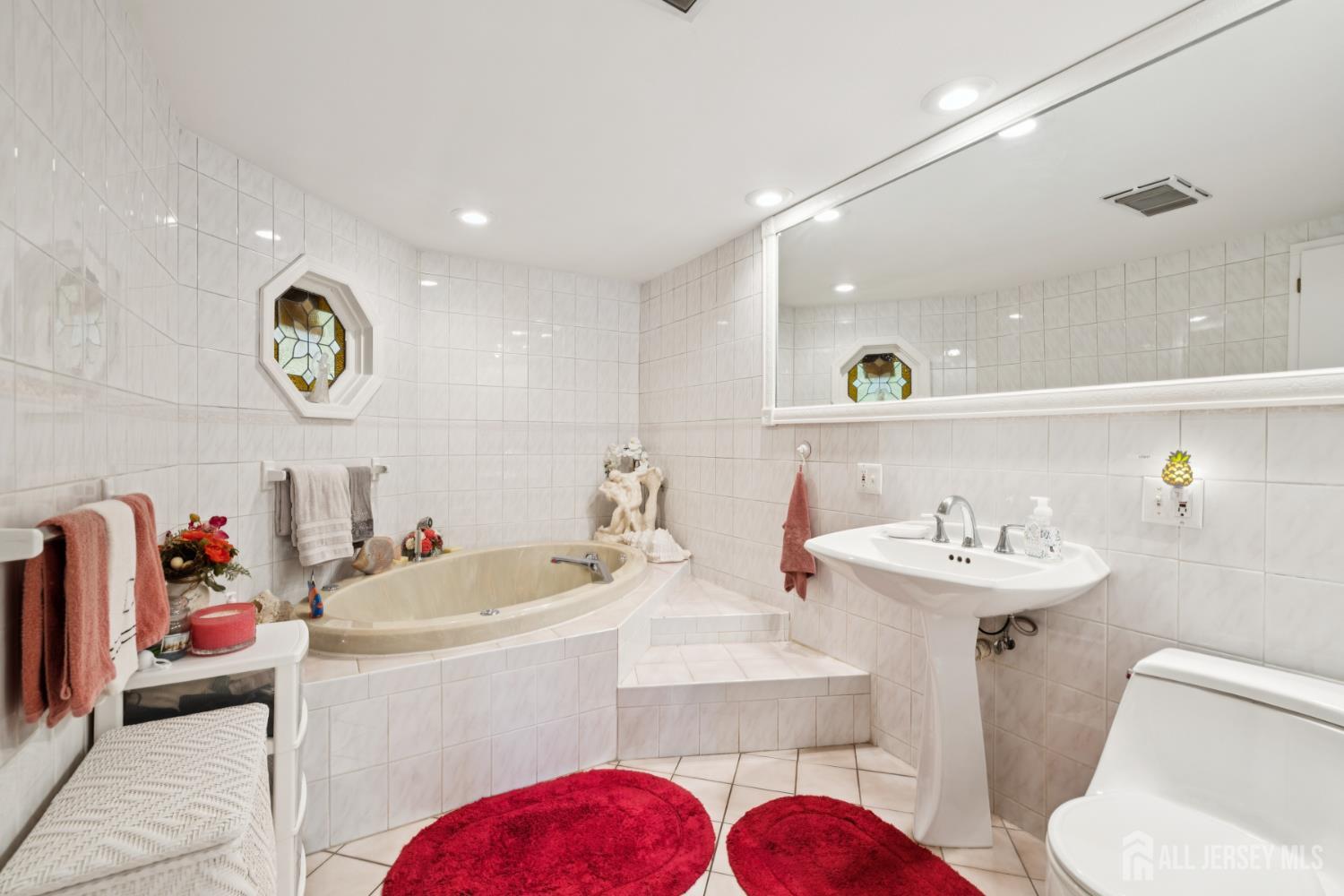 266 Amherst Avenue Colonia, NJ 07067 - Photo 10 of 22 a bathroom with a sink mirror and toilet