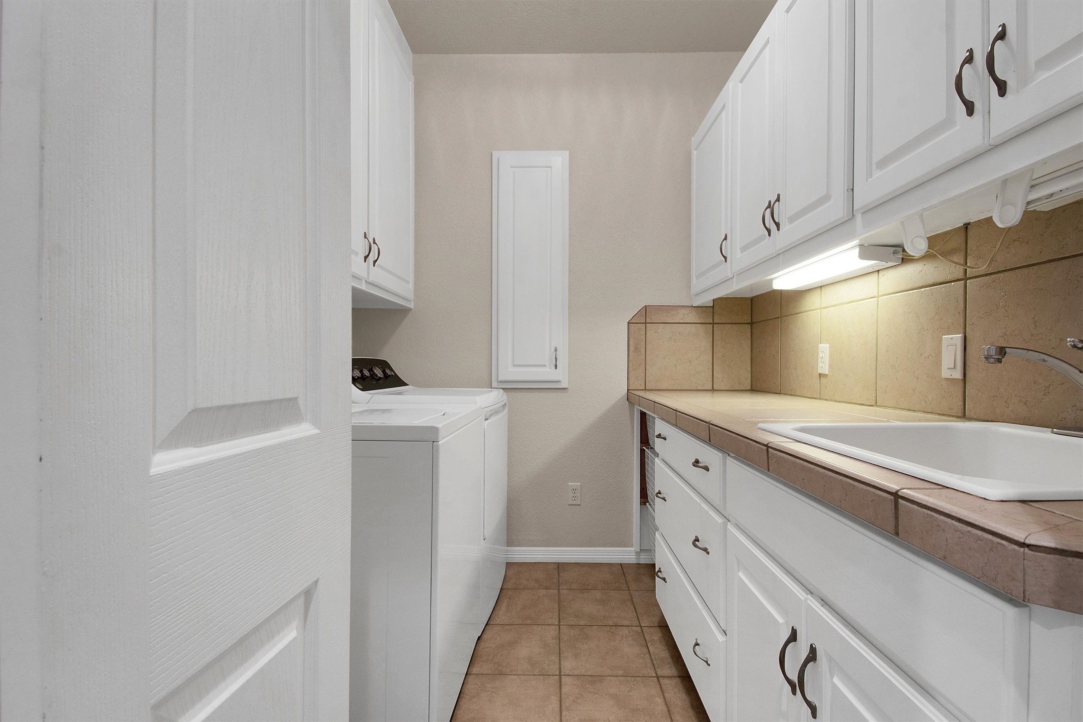 102 Lavaca Lane Georgetown, TX 78628 - Photo 26 of 30 Utility room with sink and plenty of cabinet storage, W/D convey with the home
