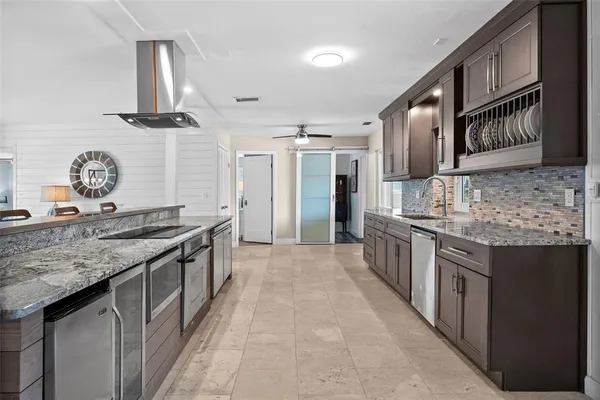 a large kitchen with stainless steel appliances granite countertop a stove oven and a sink
