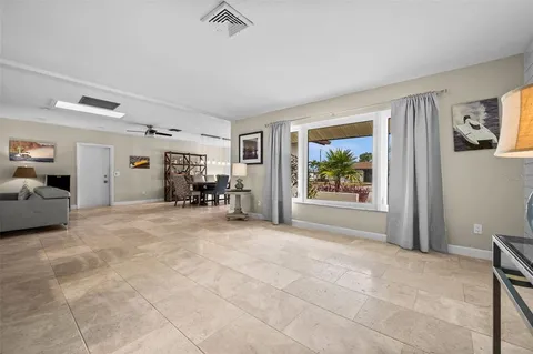a spacious bedroom with a bed and a flat tv screen on dresser
