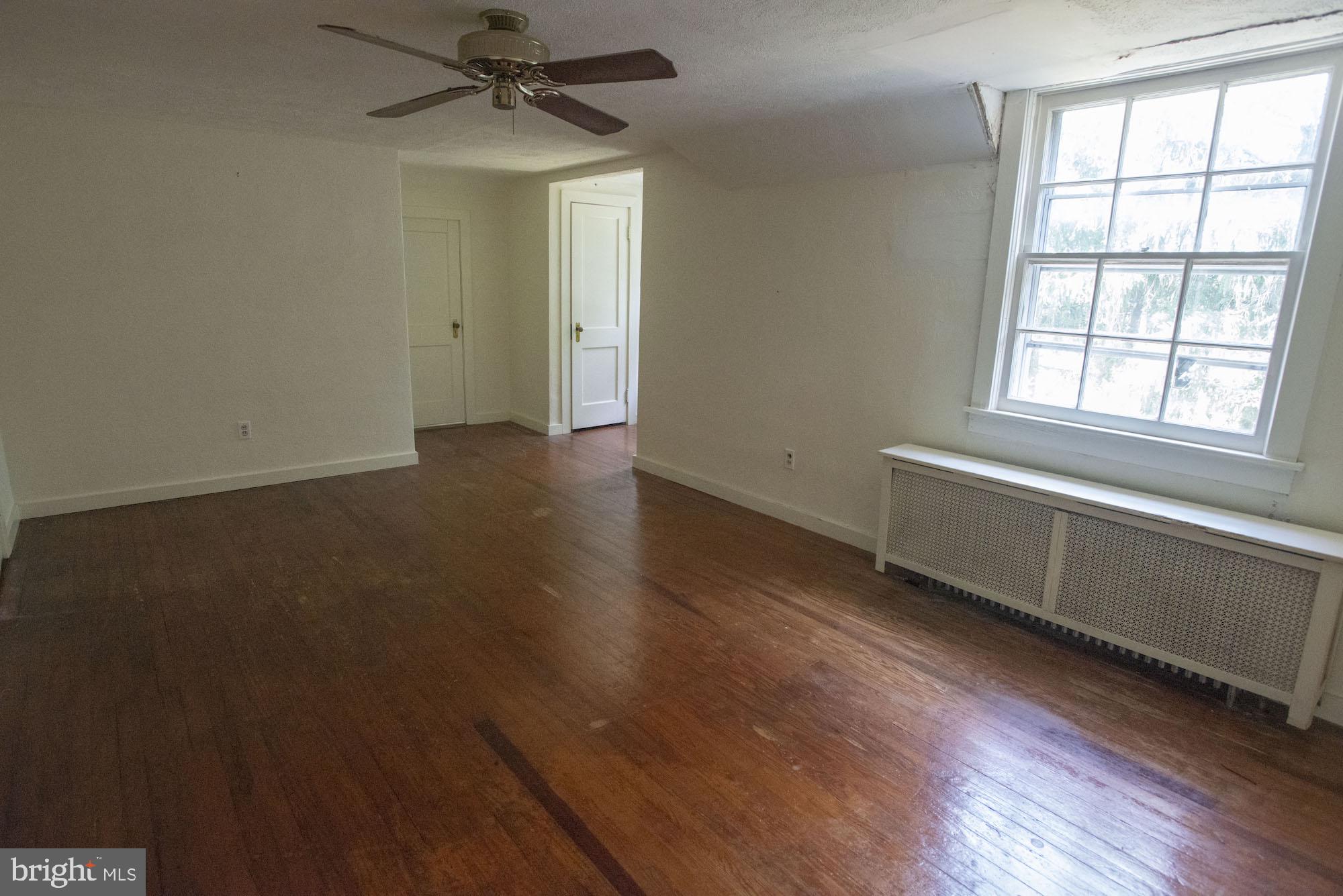 874-884 Delta Road Red Lion, PA 17356 - Photo 21 of 27 an empty room with wooden floor chandelier fan and windows
